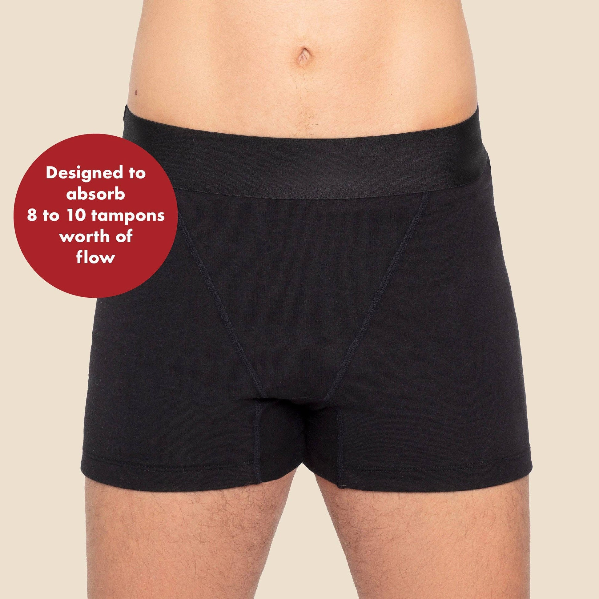 Black absorbent period shorts worn by a person on a beige background with text that says designed to absorb 8 to 10 tampons worth of flow.