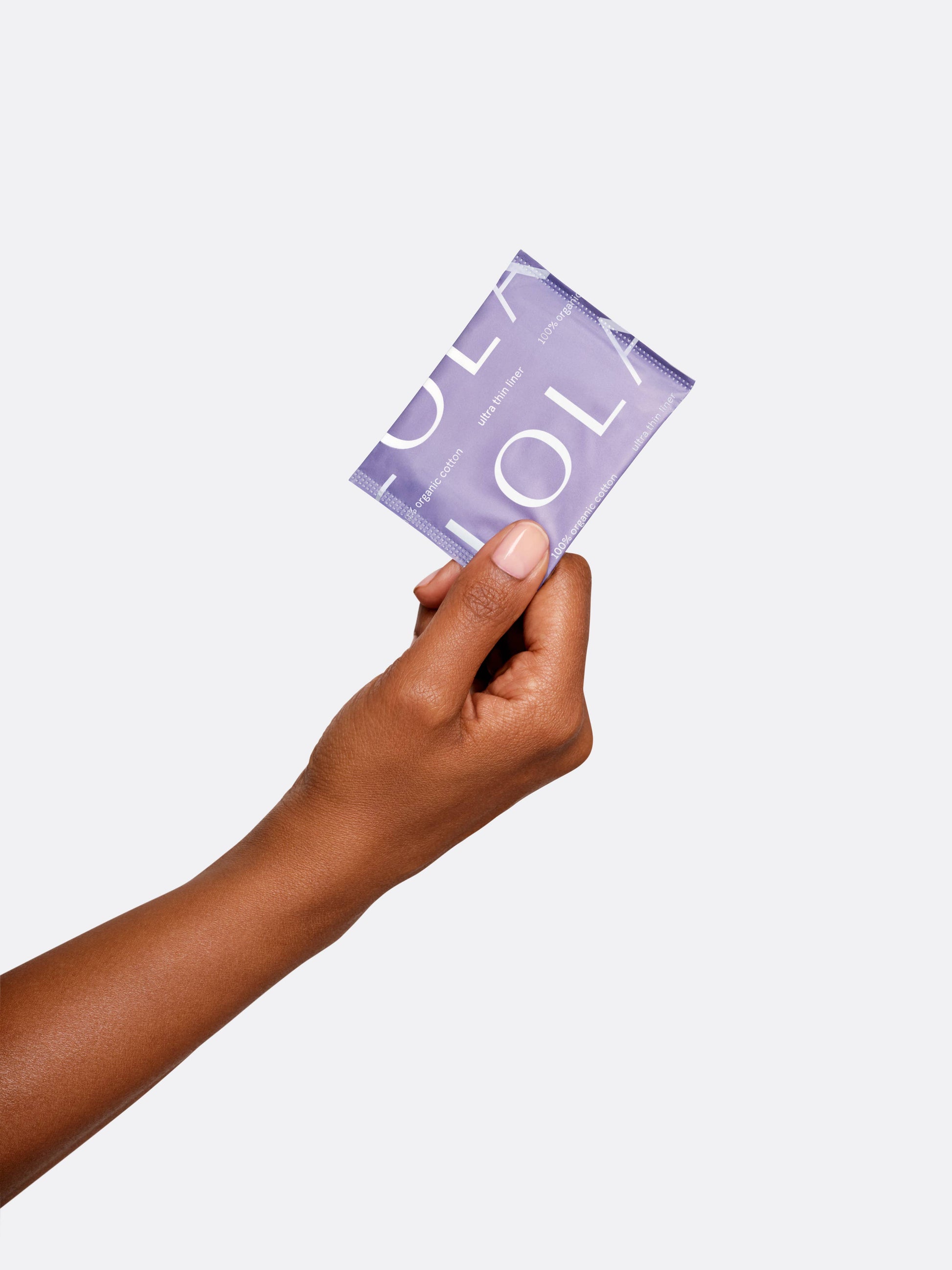 Hand holding a purple product packaging against a white background